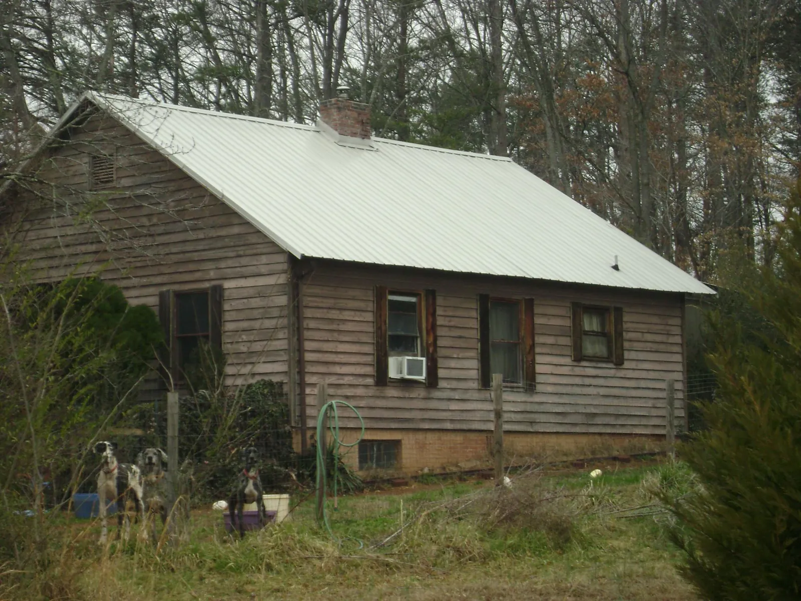 White metal roof on an old wood sided farmhouse, from a Asphalt Shingle Roof Repair job in Roberts